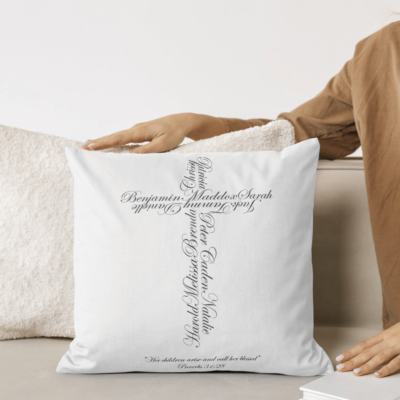 Personalized pillow placed on a couch featuring a name cross design